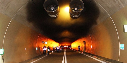 Einblick in der Innere einer Tunnelanlage mit Flammen, Rauch und Lüftungsanlage.