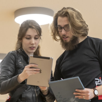 Zwei Personen schauen auf ein Tablet.