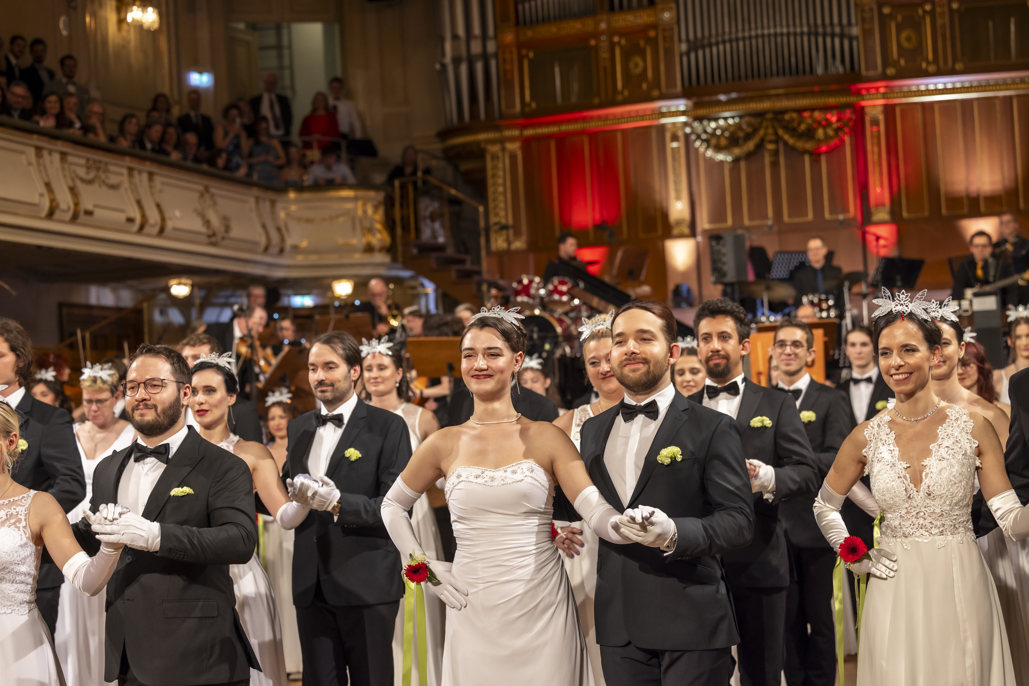 Männer und Frauen tanzen in einem Ballsaal.
