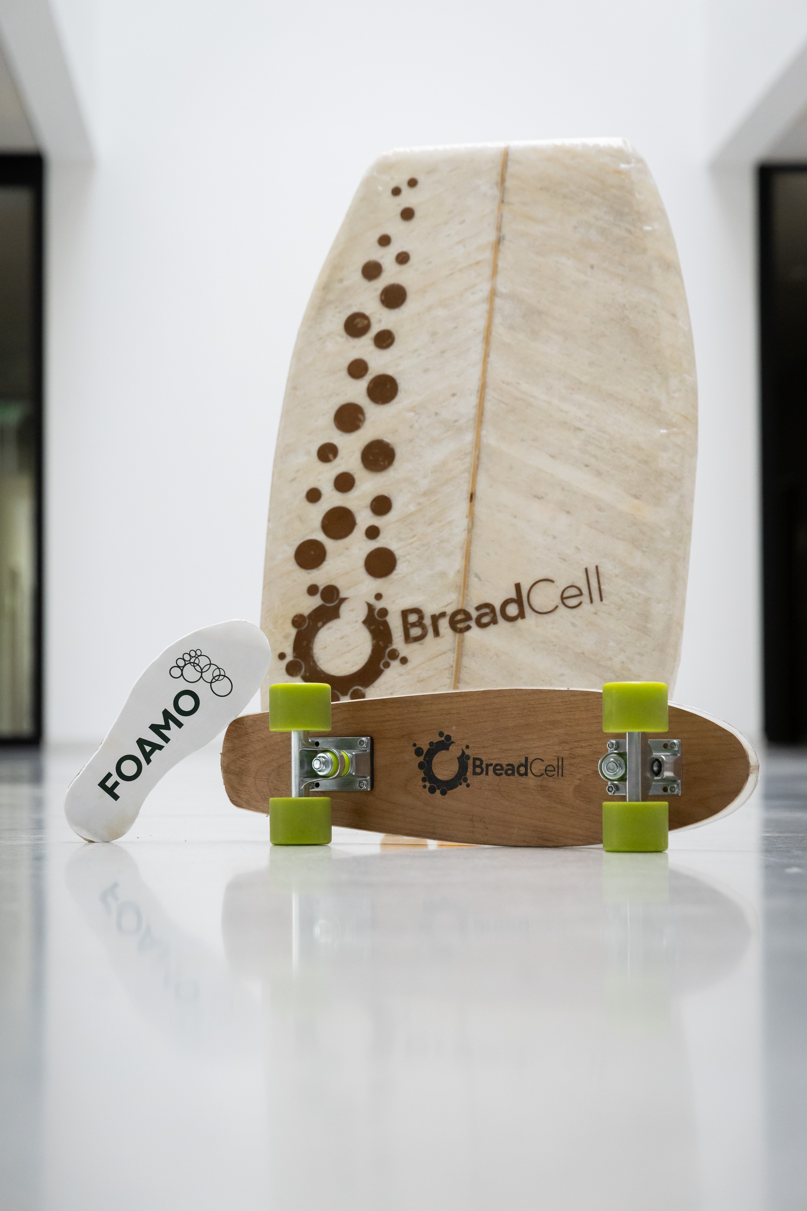 A shoe sole labelled ‘FOAMO’ as well as a bodyboard and a skateboard, each labelled ‘BreadCell’.