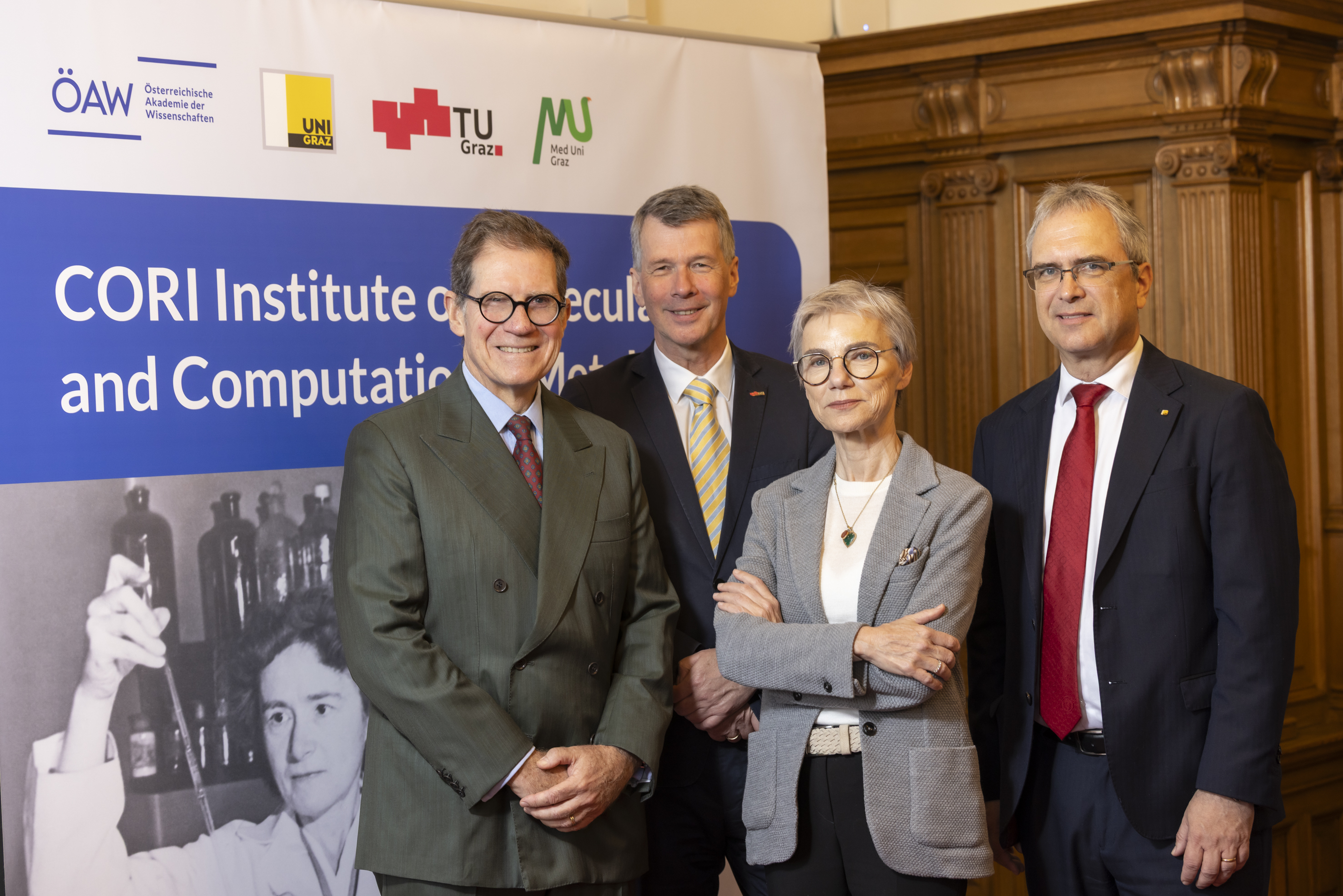 Vier Personen lächeln in die Kamera, drei Männer und eine Frau.