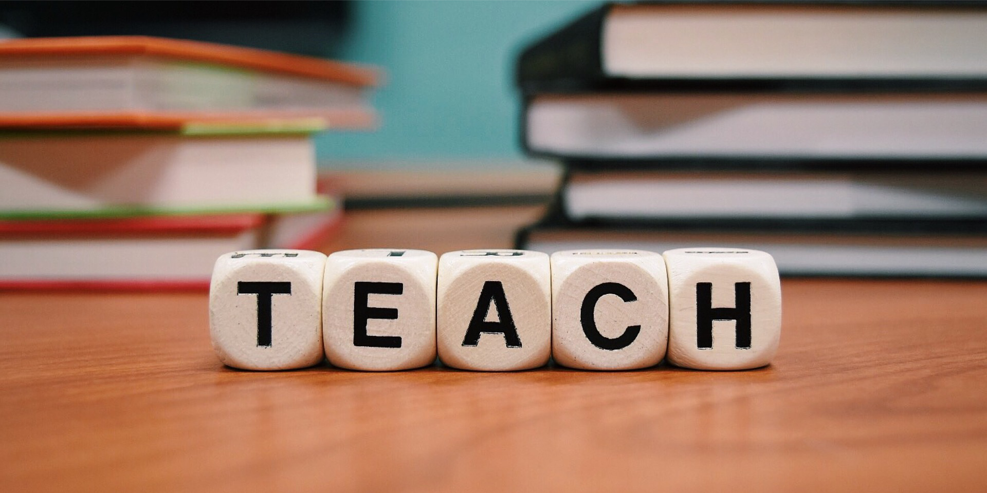 5 Würfel, die das Wort "Teach" zeigen