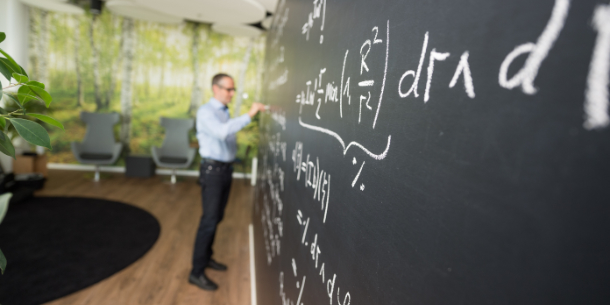 Teachers writes on a blackboard.